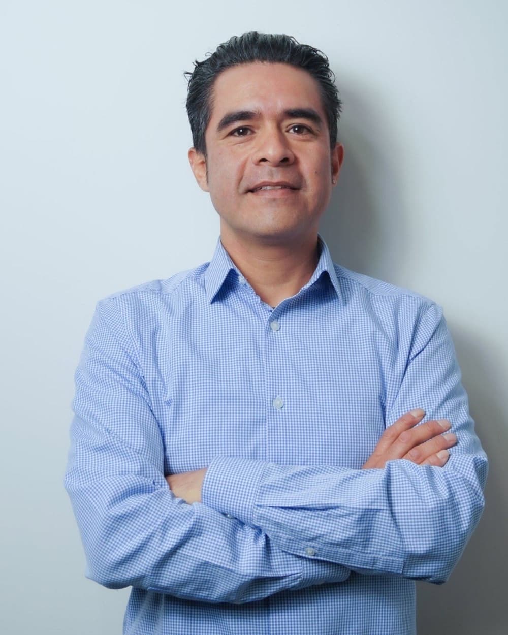 Javier Pérez, asesor de Legado, de brazos cruzados con camisa azul